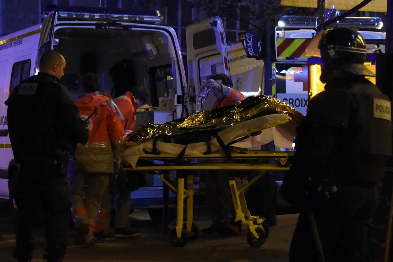 Rescue workers evacuate an injured person near the Bataclan concert hall in central Paris. 