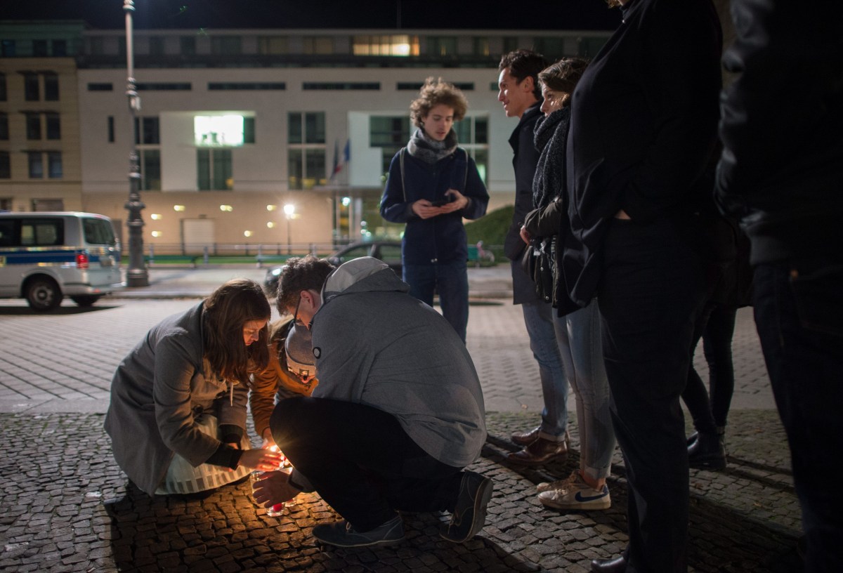 epa05023962 People light candles in tribute to the victims of the Paris attacks, outside the French embassy in Berlin, Germany, 13 November 2015. Dozens of people have been killed in a series of attacks in Paris on 13 November. EPA/LUKAS SCHULZE
