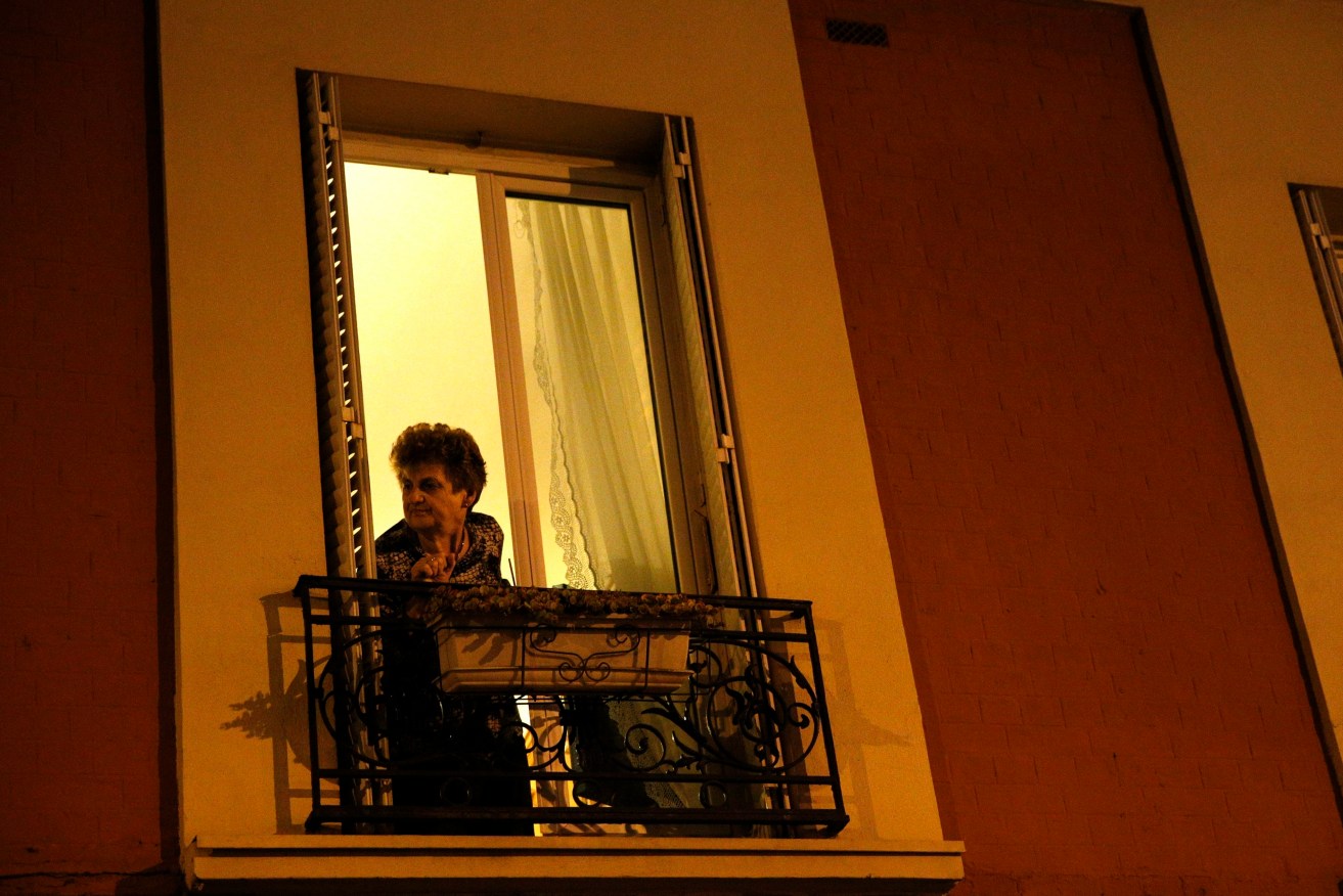 A person peers from their window as police in Paris as police raid an apartment block in Saint  Denis. EPA/YOAN VALAT