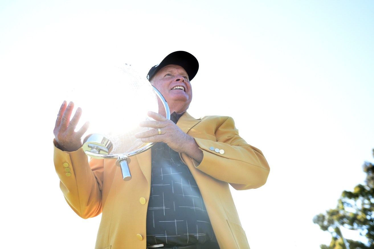 Peter Senior celebrates with the championship trophy after winning the Australian Masters Golf Tournament at Huntingdale in Melbourne. AAP photo