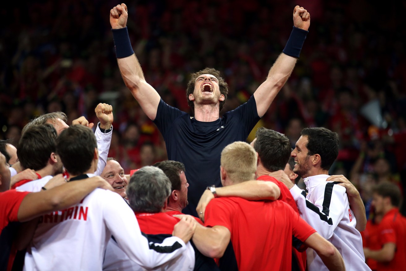 A jubilant Andy Murray is mobbed by his team-mates after beating David Goffin to secure the Davis Cup for Britain. Photo:  Andrew Milligan/PA Wire