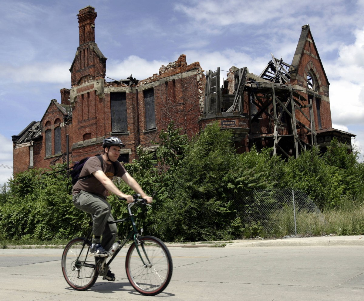 A resident passes an abandoned home in what was once a thriving middle class area in Detroit in 2005. AFP PHOTO/JEFF HAYNES