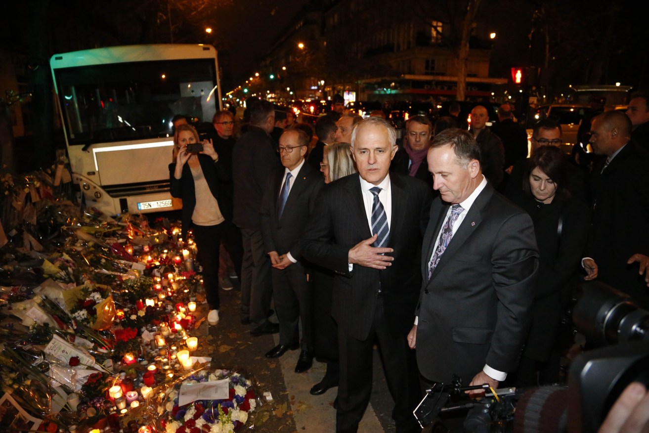 Prime Minister Malcolm Turnbull  (centre) and New Zealand counterpart John  Key pay tribute to the victims of Paris' terrorist attacks in front of the Bataclan concert hall. AFP PHOTO / MATTHIEU ALEXANDRE