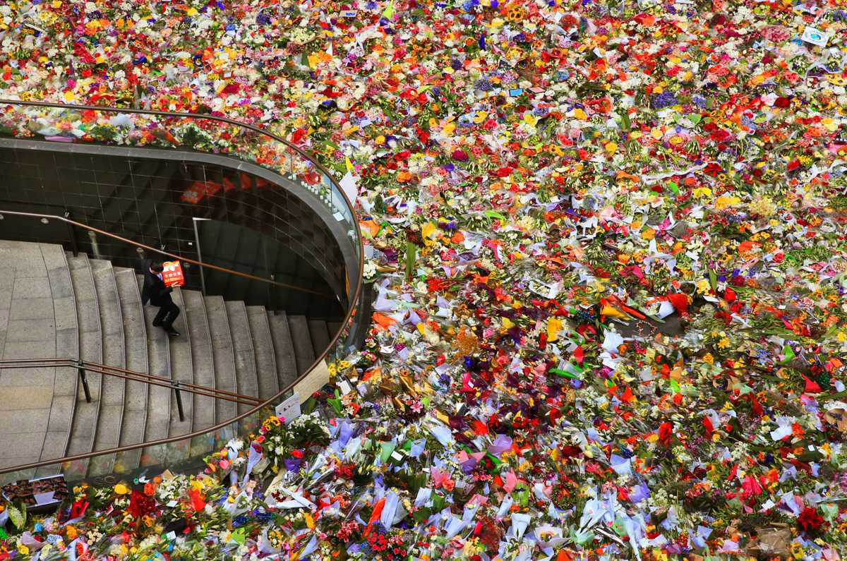 Sydney’s Heart: A solitary office worker walking down the stairs at Martin Place, which is surrounded by floral tributes. Photo by Toby Zerna