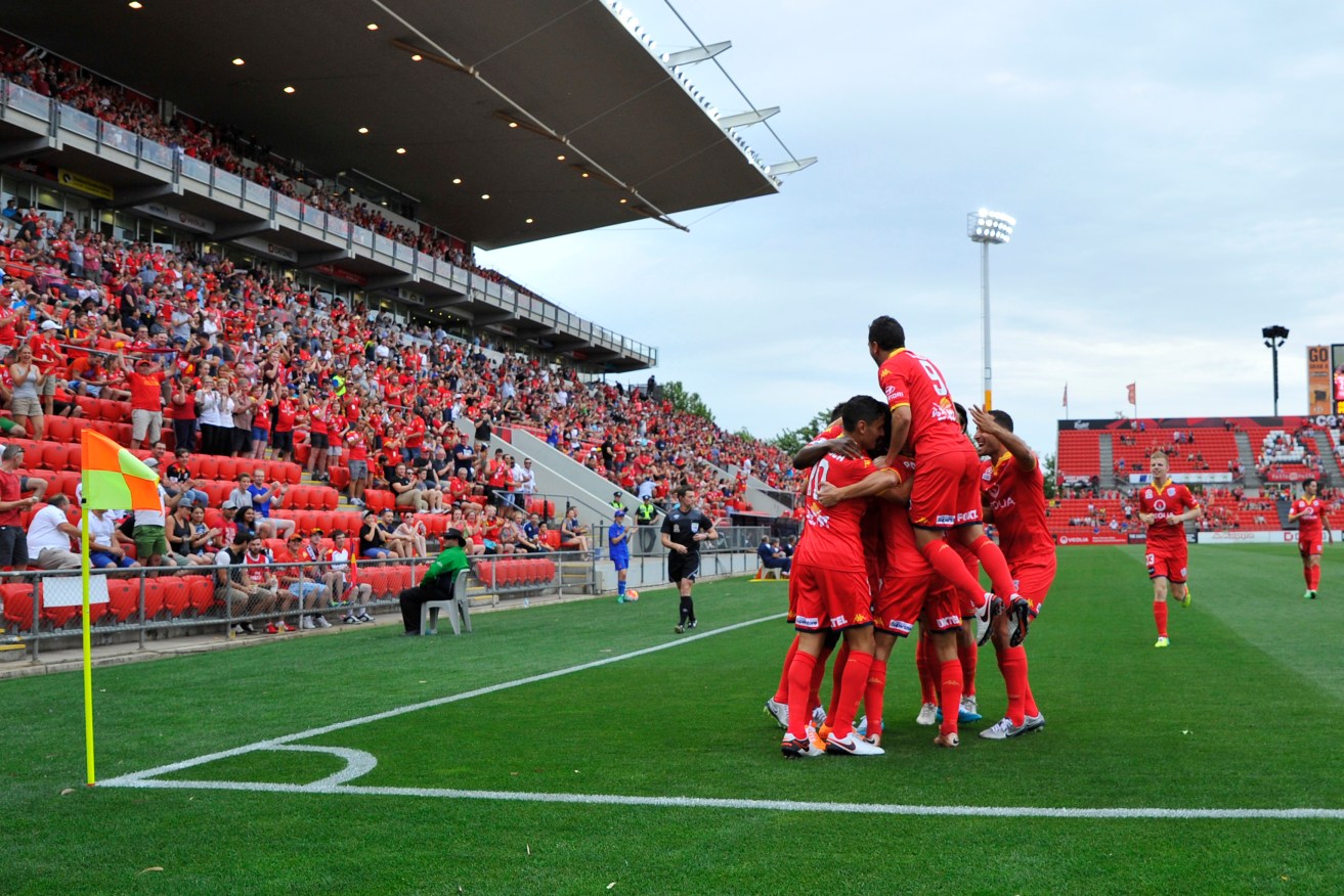 Adelaide United players celebrate an early goal against Perth Glory at Coopers Stadium on Sunday. AAP Image/David Mariuz