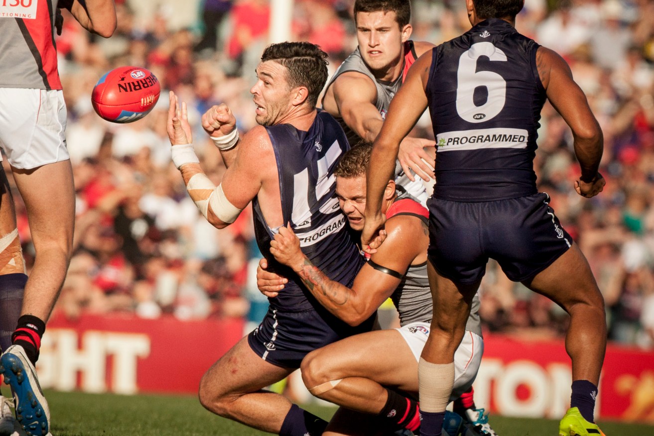 Ryan Crowley takes on the Bombers in 2014. He now says he wants to "protect" their younger players. Photo: Tony McDonough, AAP.