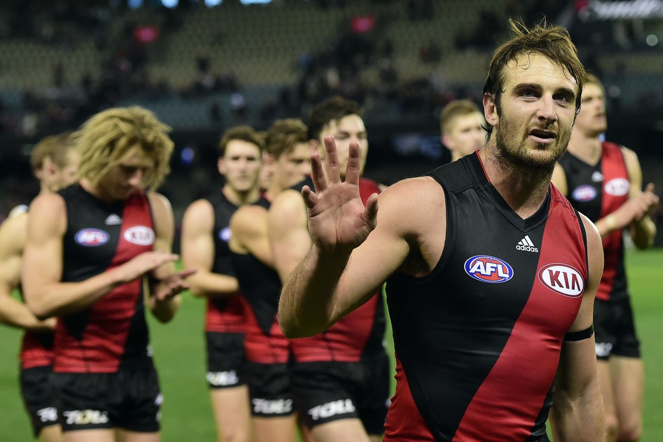 Jobe Watson leads his teammates off the field after a defeat last year. Neither he nor 16 other players will take the field this year. Photo: Julian Smith, AAP.