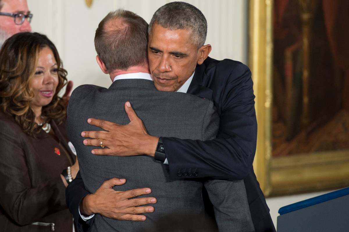 epa05088863 US President Barack Obama (R) hugs Mark Barden, whose son Daniel was seven years old when shot and killed at the Sandy Hook Elementary School attack in 2012, at an event held to announce executive actions to reduce gun violence, in the East Room of the White House in Washington, DC, USA, 05 January 2016. Obama outlined measures such as strengthening background checks for purchasing guns and requiring individuals that sell firearms to register as licensed gun dealers. EPA/MICHAEL REYNOLDS