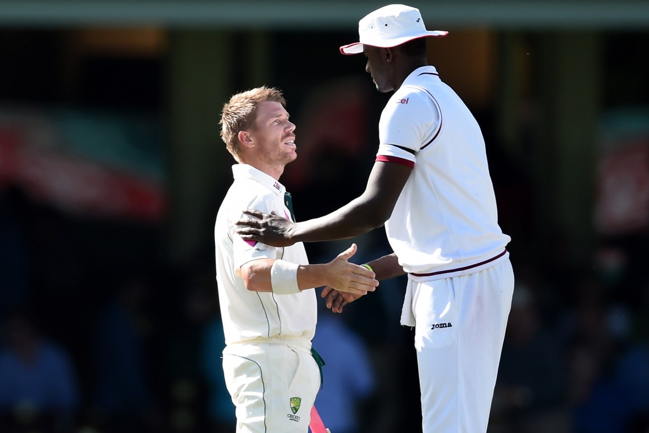 Warner shakes hands with Jason Holder of the West Indies at the end the fifth day of the largely-washed-out third Test. Photo: Paul Miller, AAP.