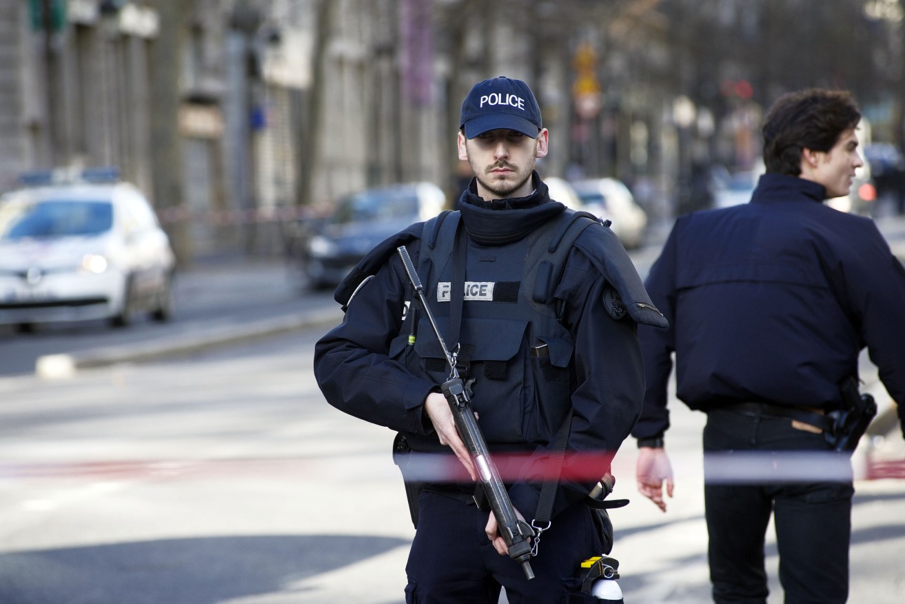 An officer of the French national police stands armed near the Rue de la Goutte d'Or after police shot dead a man who attempted to attack a police station. Photo: PATRICE PIERROT / NEWZULU / AAP.