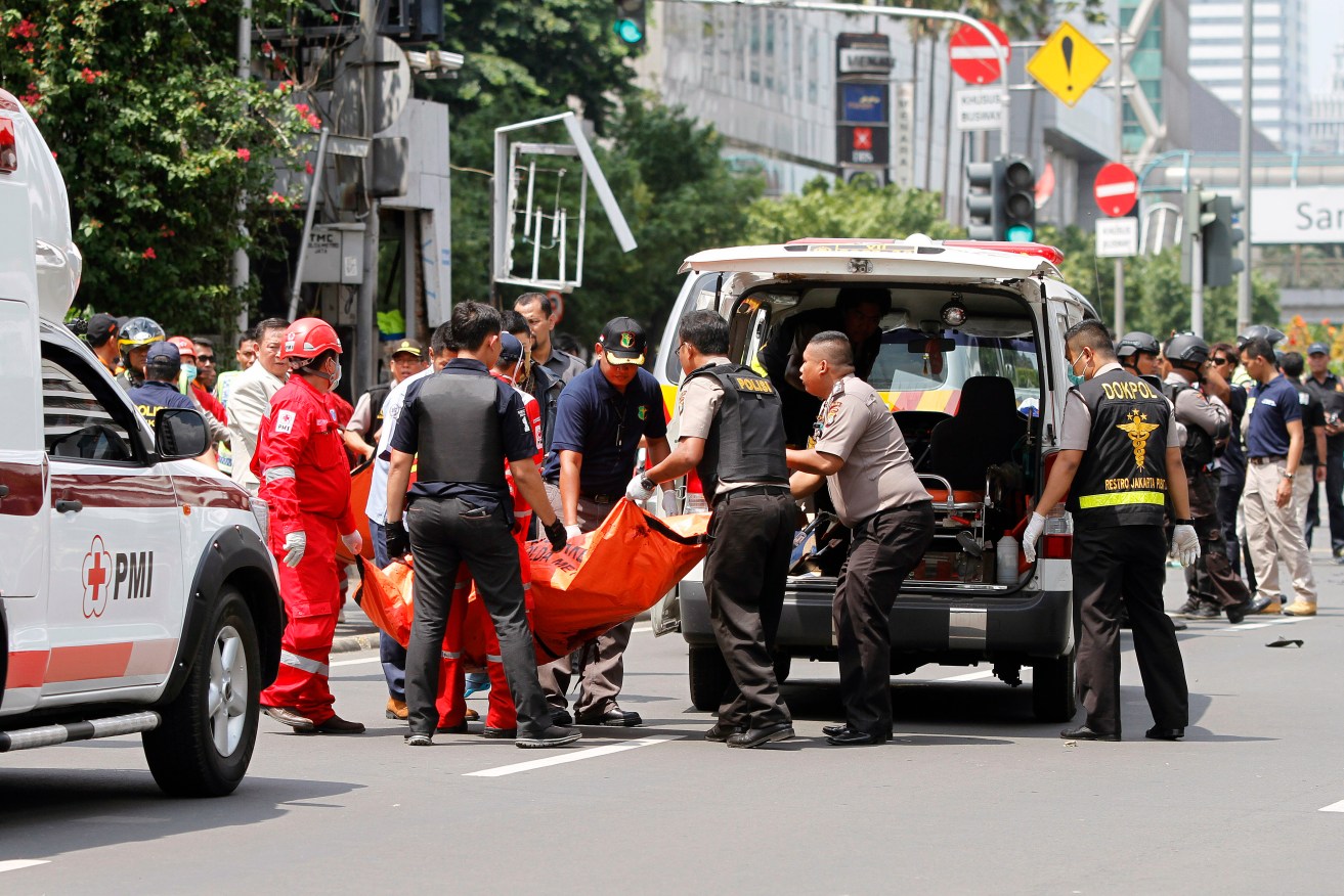Members of a medical team carry the body of a victim into an ambulance at the scene of a bomb blast in Jakarta, Indonesia. AAP Image/Roni Bintang