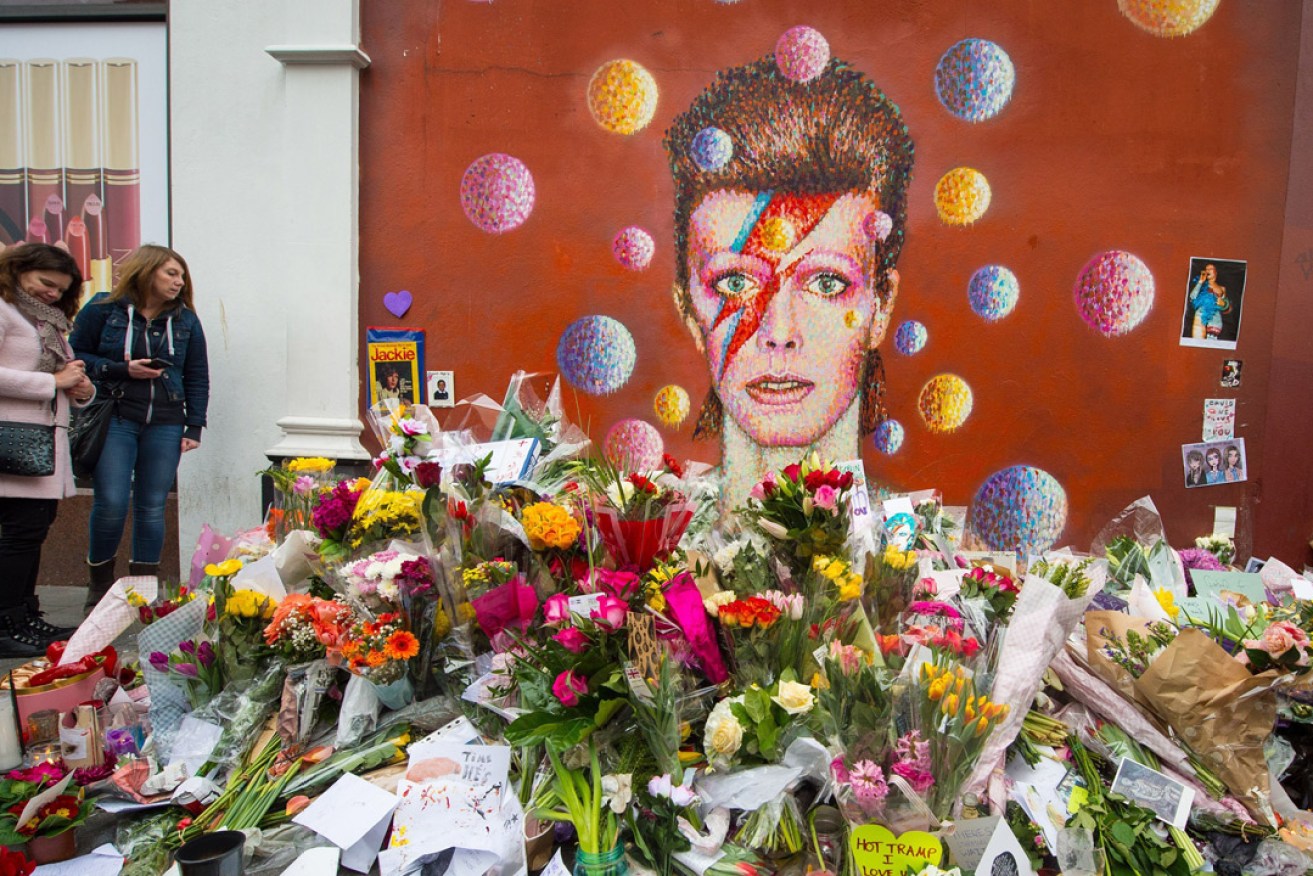 Flowers left at a mural paying tribute to David Bowie in London. Photo: PA