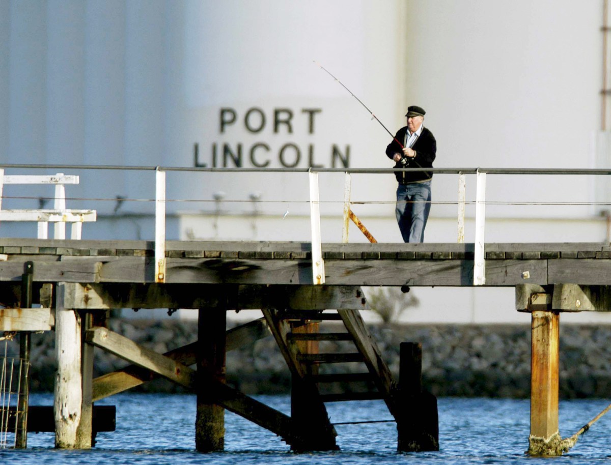 Pt. Lincoln, SA, 2nd December, 2002. A local resident fishing off the town's public jetty with the "AusBulk" grain Silo Complex in the background. Both are on the edge of town and in Boston Bay, the silo complex is for the export of Eyre Peninsula's grain production. (AAP Image/Rob Hutchison) NO ARCHIVING