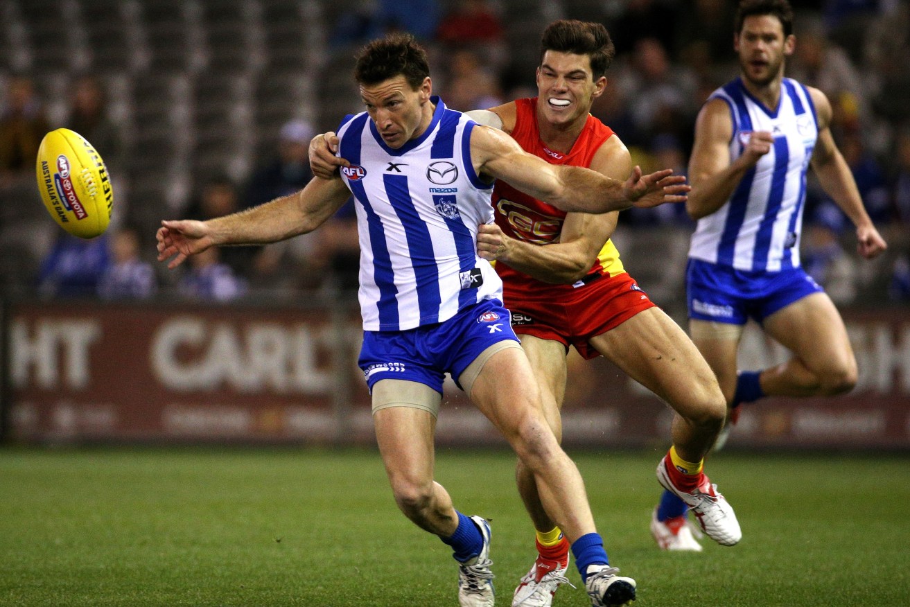 JAEGER BOMBSHELL? O'Meara tackles Kangaroo Brent Harvey in 2014 - but could he be suiting up in North Melbourne colours next year? Photo: Mark Dadwell, AAP.