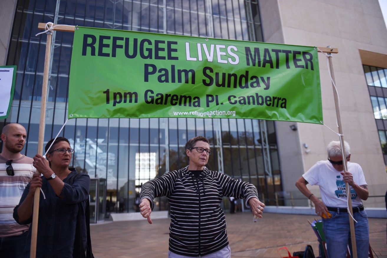 Asylum seeker advocates react to the High Court's decision outside the court today.  Photo: AAP/Mick Tsikas