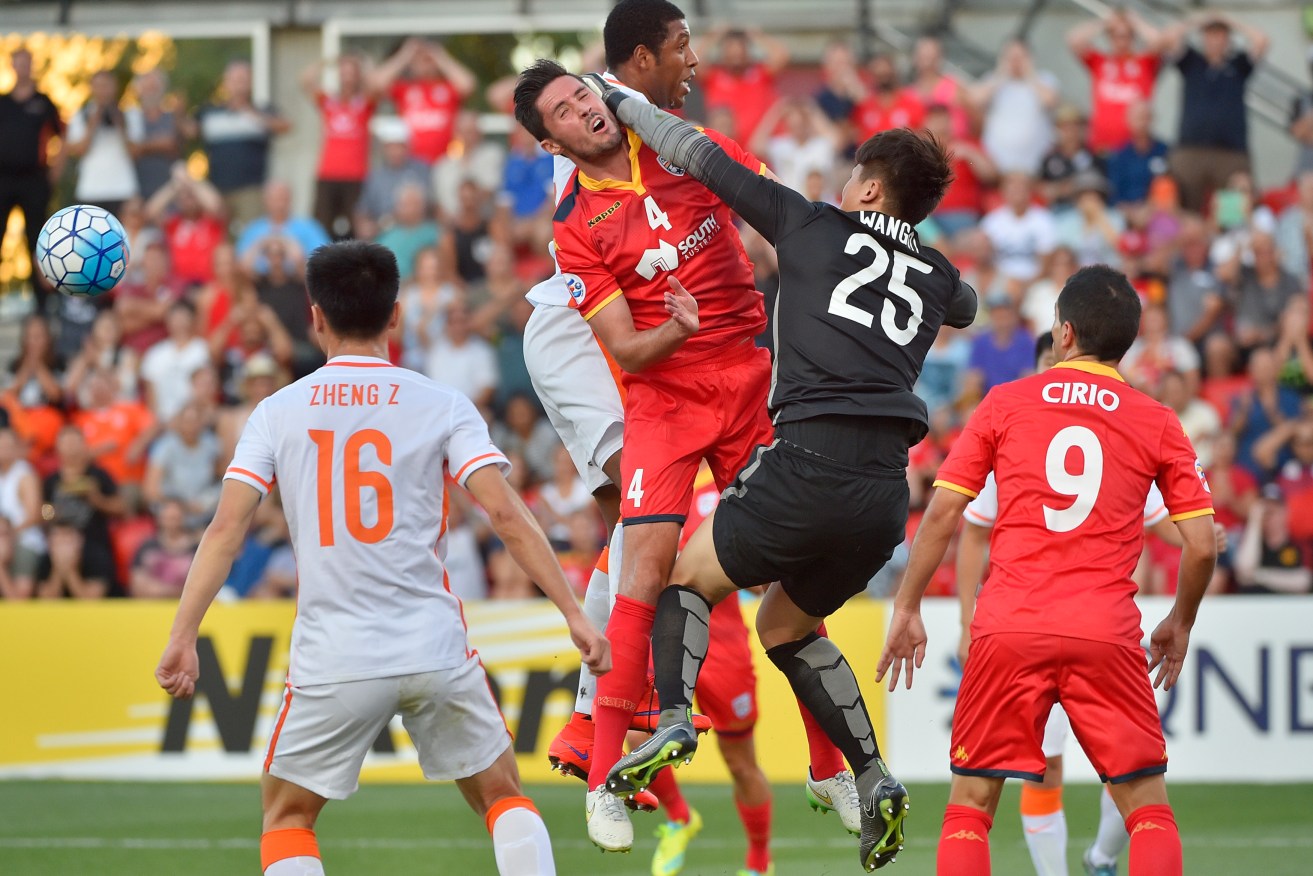 Keeper Wang Dalei of Shandong Luneng punches the ball away from United's Dylan McGowan. Photo: David Mariuz, AAP.
