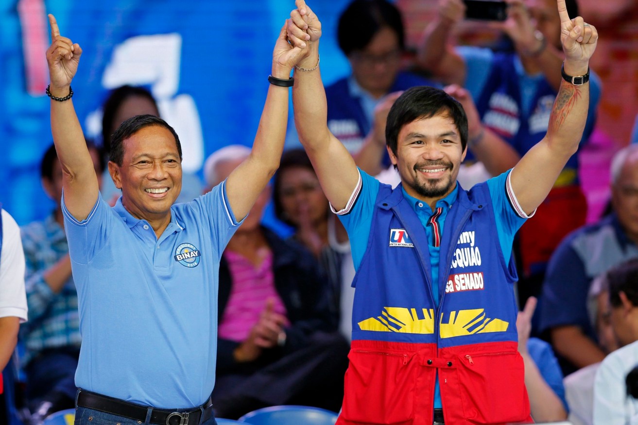 Filipino presidential hopeful vice-president Jejomar Binay and boxing champion Emmanuel Manny Pacquiao raise hands at the start of their presidential campaign in Mandaluyong City. Photo: FRANCIS R. MALASIG, EPA.