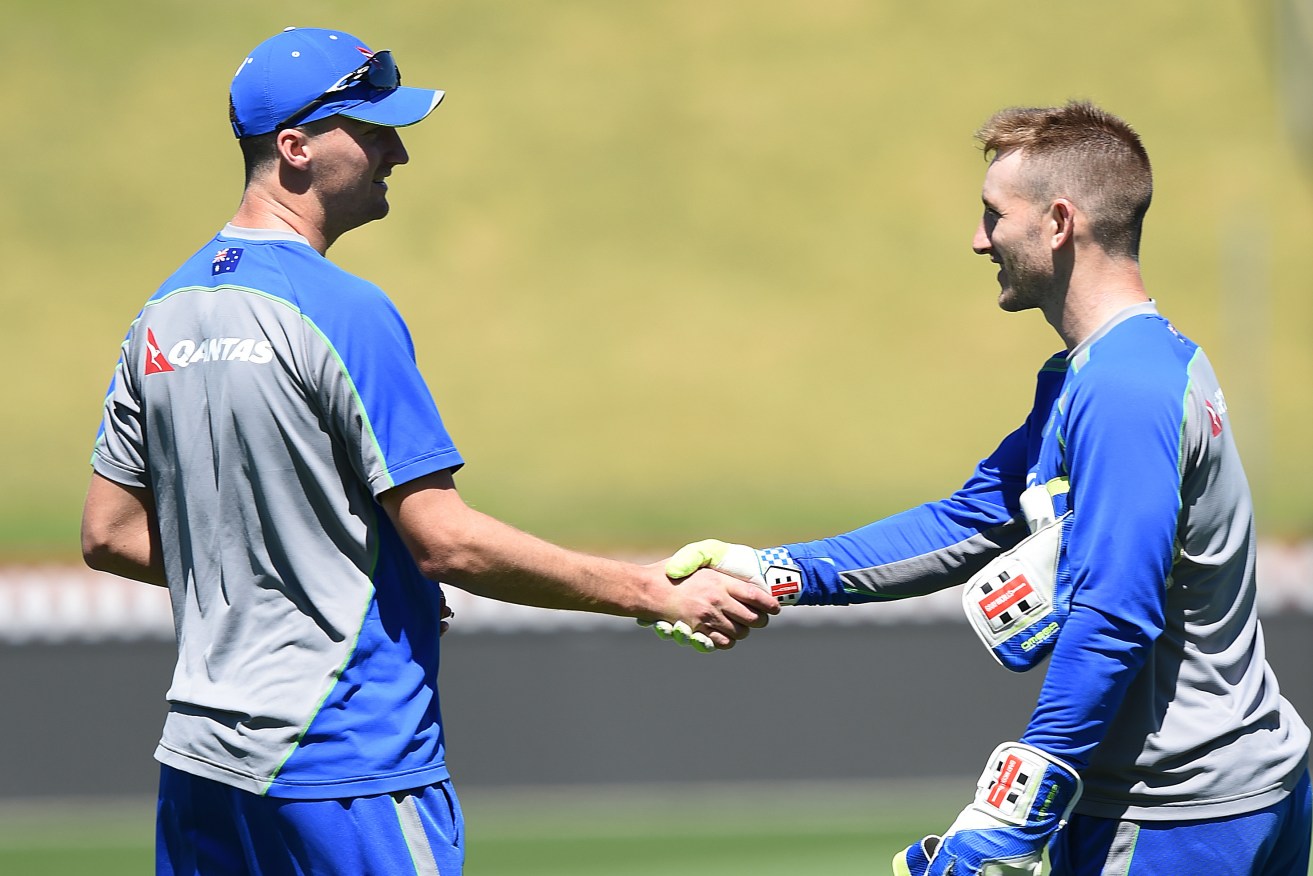Jackson Bird (left) is congratulated by wicketkeeper Peter Nevill during yesterday's Australian team training session. Photo: Dave Hunt, AAP.