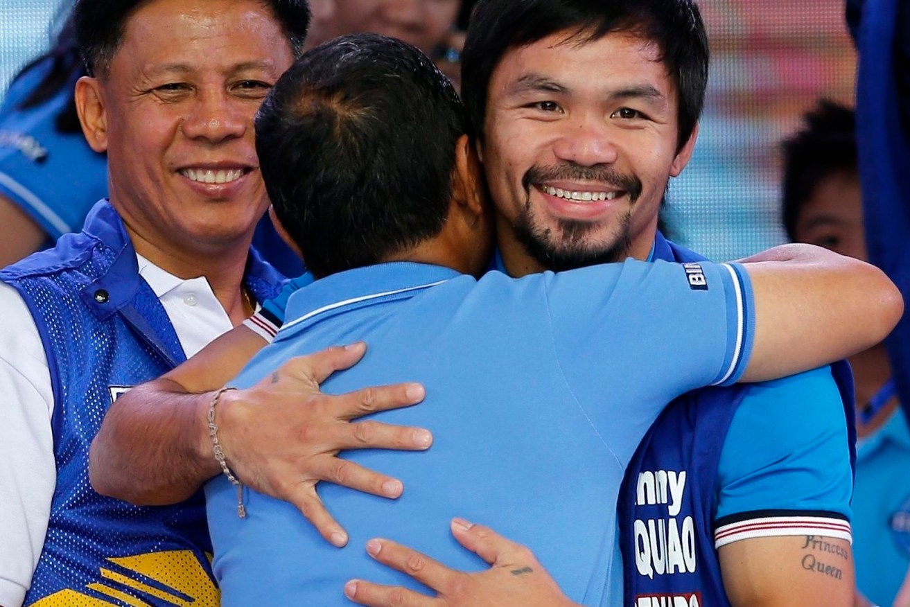 Manny Pacquiao embraces Philippine vice-president Jejomar Binay during a political gathering in Mandaluyong city, east of Manila. Filipinos will vote for 12 of 24 senators on May 9. Photo: FRANCIS R. MALASIG, EPA.