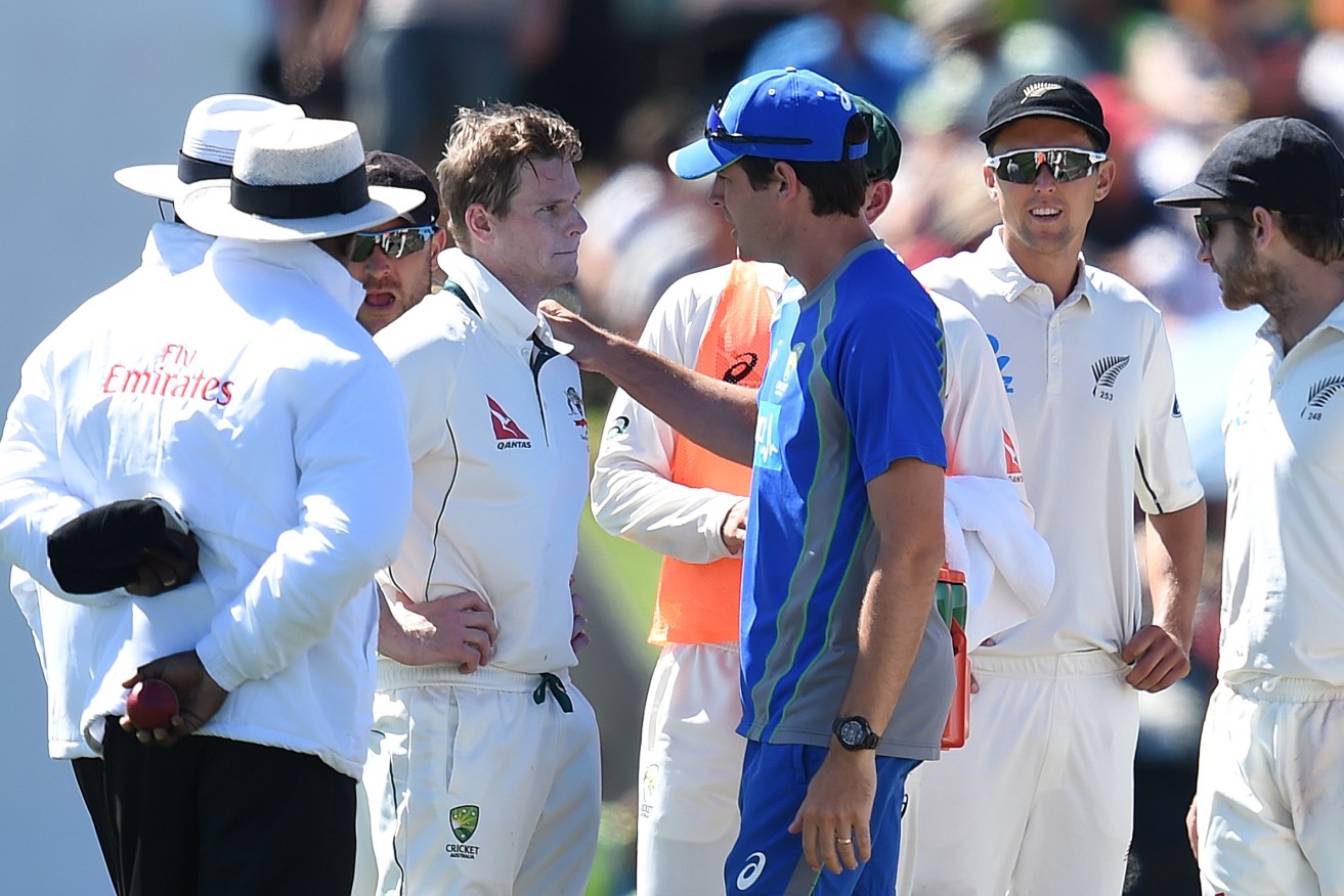 Australian captain Steve Smith recieves attention after being hit in the head by a ball bowled by New Zealand's Neil Wagner.  Photo: Dave Hunt, AAP.