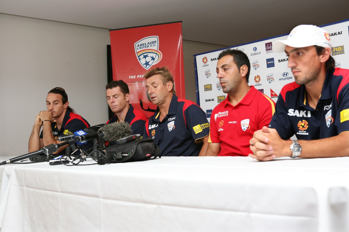 Adelaide United coach John Kosmina (centre) speaks to the media as players (L-R:) Angelo Constanzo, Carl Veart, Ross Aloisi and Michael Valkanis look on in Adelaide, Tuesday, Feb. 20, 2007. Kosmina apologised for his behaviour and comments made during his team's A League Grand Final campaign. (AAP Image/Bryan Charlton) NO ARCHIVING