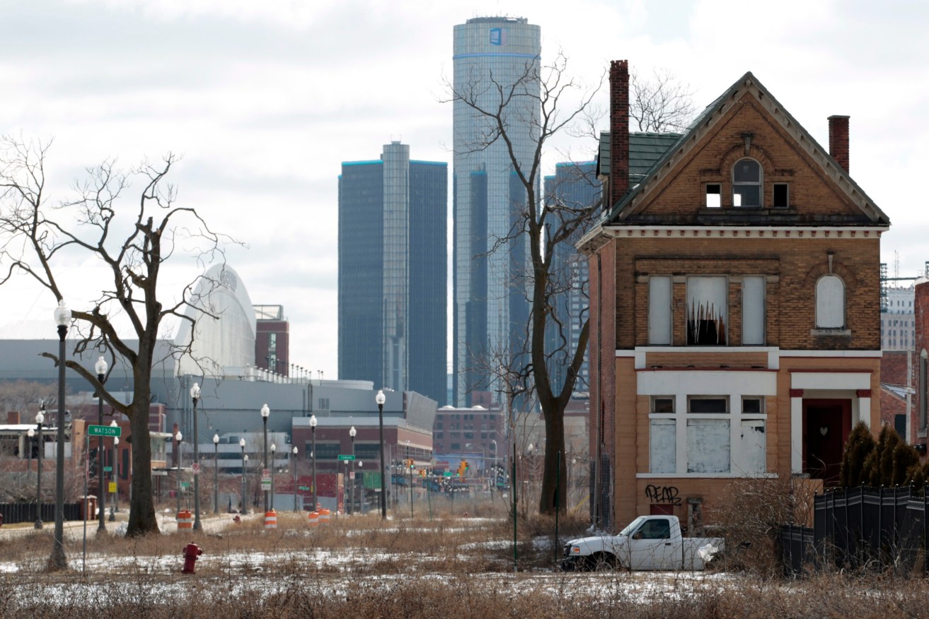 Scenes from the rust belt: a 2013 picture of an empty house with the GM building  in the background in downtown Detroit. Photo: EPA/Jeff Kowalsky
