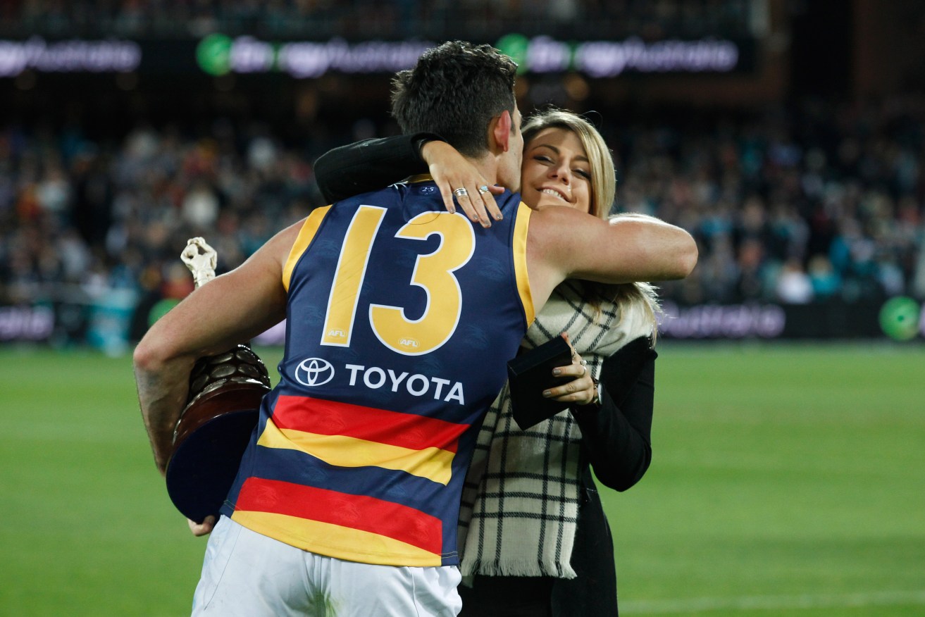 Crows captain Taylor Walker embraces Phil Walsh's daughter Quinn after last year's second Showdown. He says he is fit to play this week, despite battling foot soreness. Photo: Ben Macmahon, AAP.