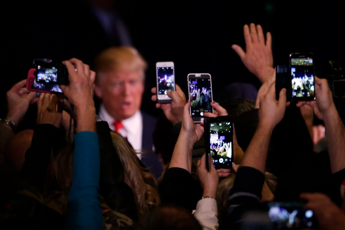 Supporters take photos of Donald Trump on their mobile phones. Photo: AP/Marcio Jose Sanchez