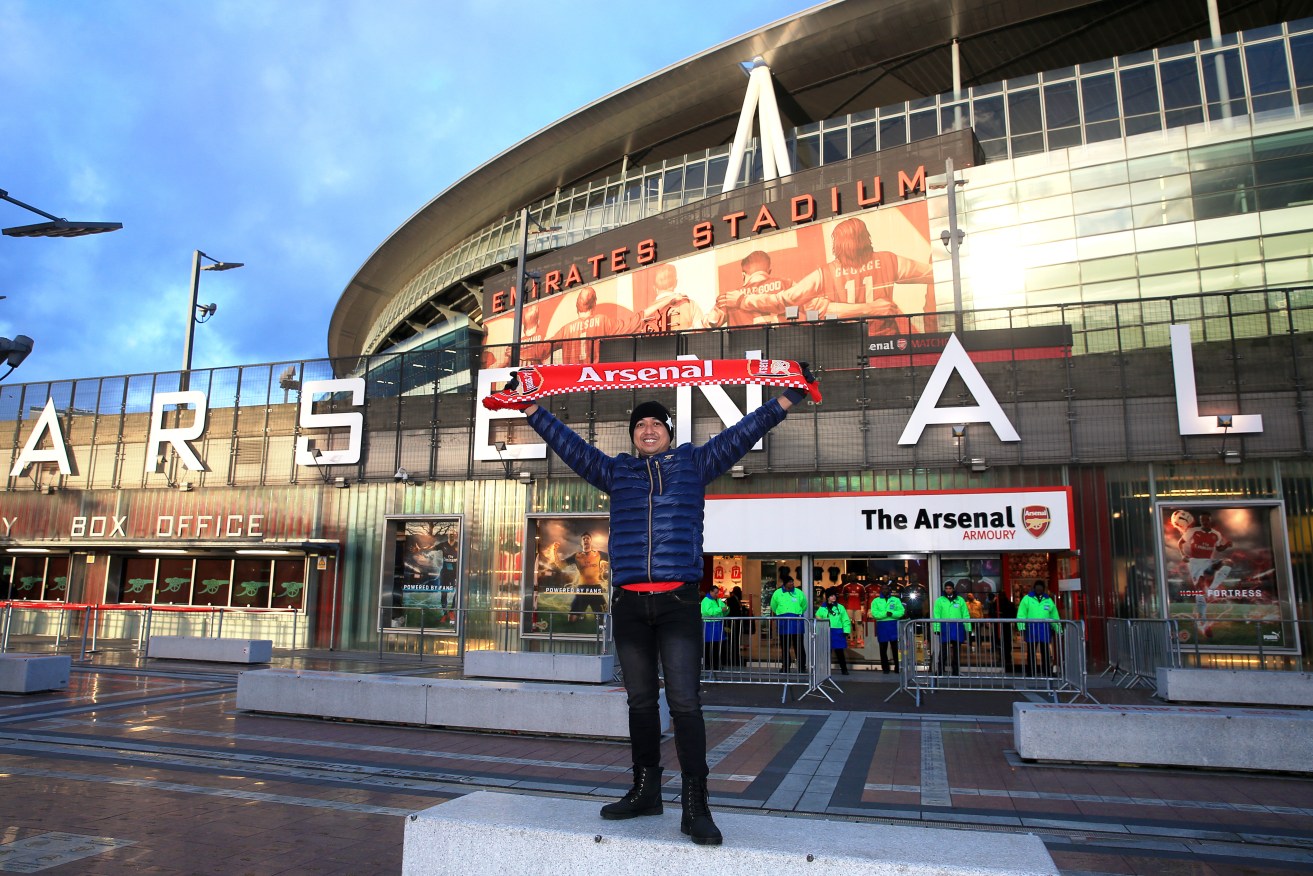 An Arsenal fan poses outside Emirates Stadium, London. Photo: Nick Potts, PA Wire. 