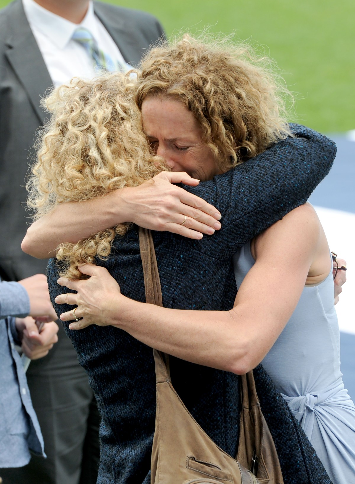 Geraldine Couch (right) is embraced by a friend at a memorial service to celebrate the life of Geelong champion Paul Couch at Simonds Stadium in Geelong, Tuesday, March. 15, 2016. (AAP Image/Mal Fairclough) NO ARCHIVING