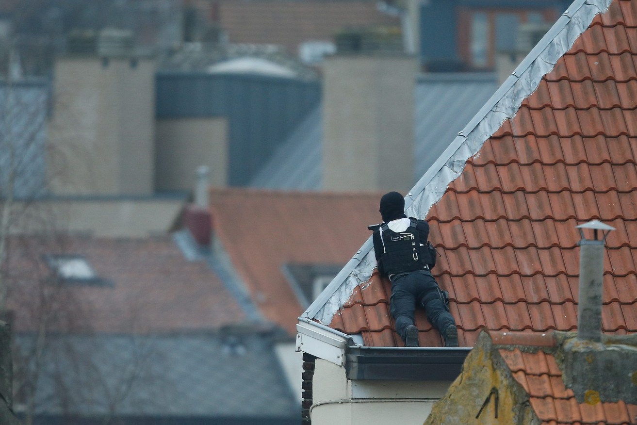 A police officer takes position on a rooftop during an operation in Forest, Brussel. Photo:  EPA/Laurent Dubrule