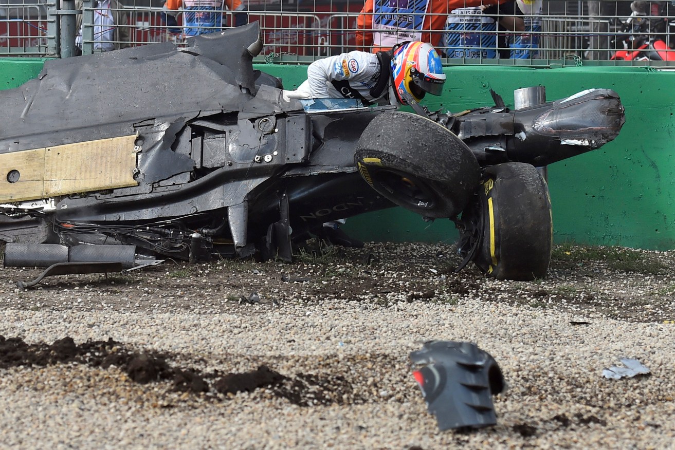 Spaniard Fernando Alonso climbs out of his wrecked car. Photo: Theo Karanikos, AP.