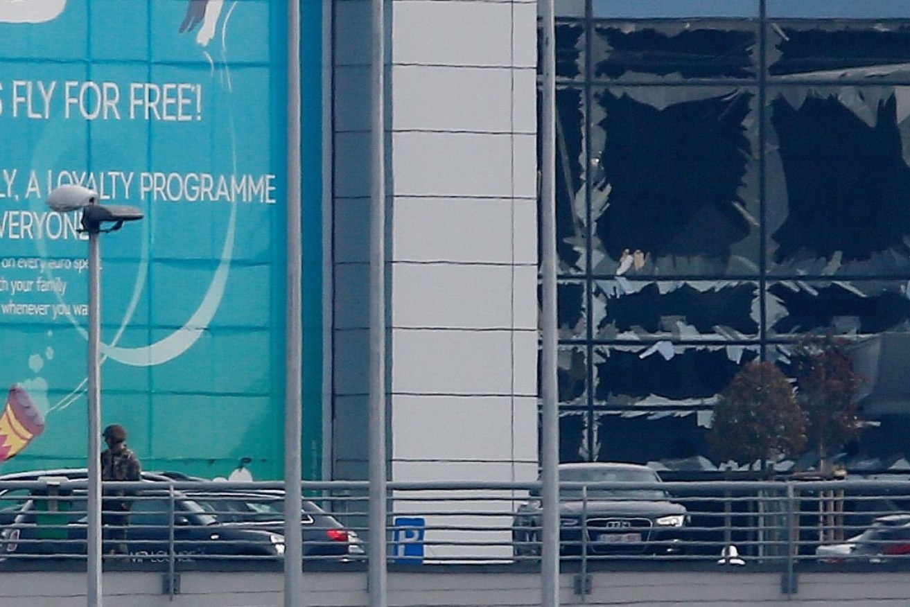 Members of the Belgian security service near the blown-out windows of the Zaventem Airport. Photo: EPA/LAURENT DUBRULE