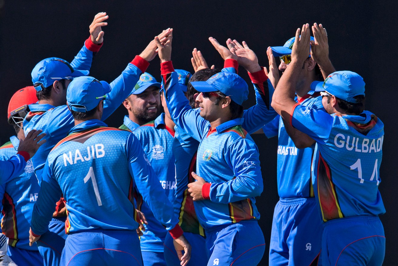 Afghanistan's cricketers celebrate the wicket of England's Jos Buttler. Photo: Manish Swarup, AP.
