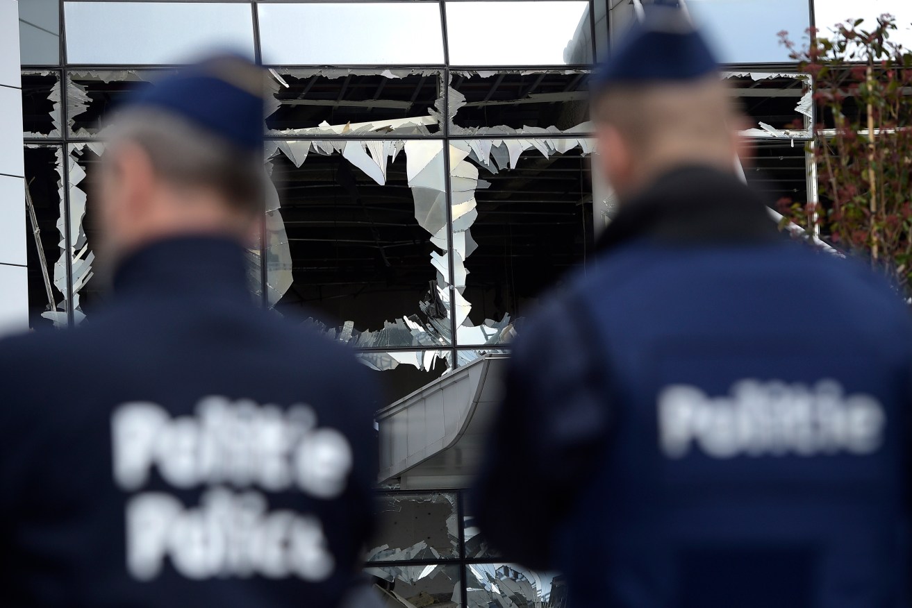 Two police officers stand in front of blown out windows at Zaventem Airport in Brussels. Photo: AP/Yorick Jansens