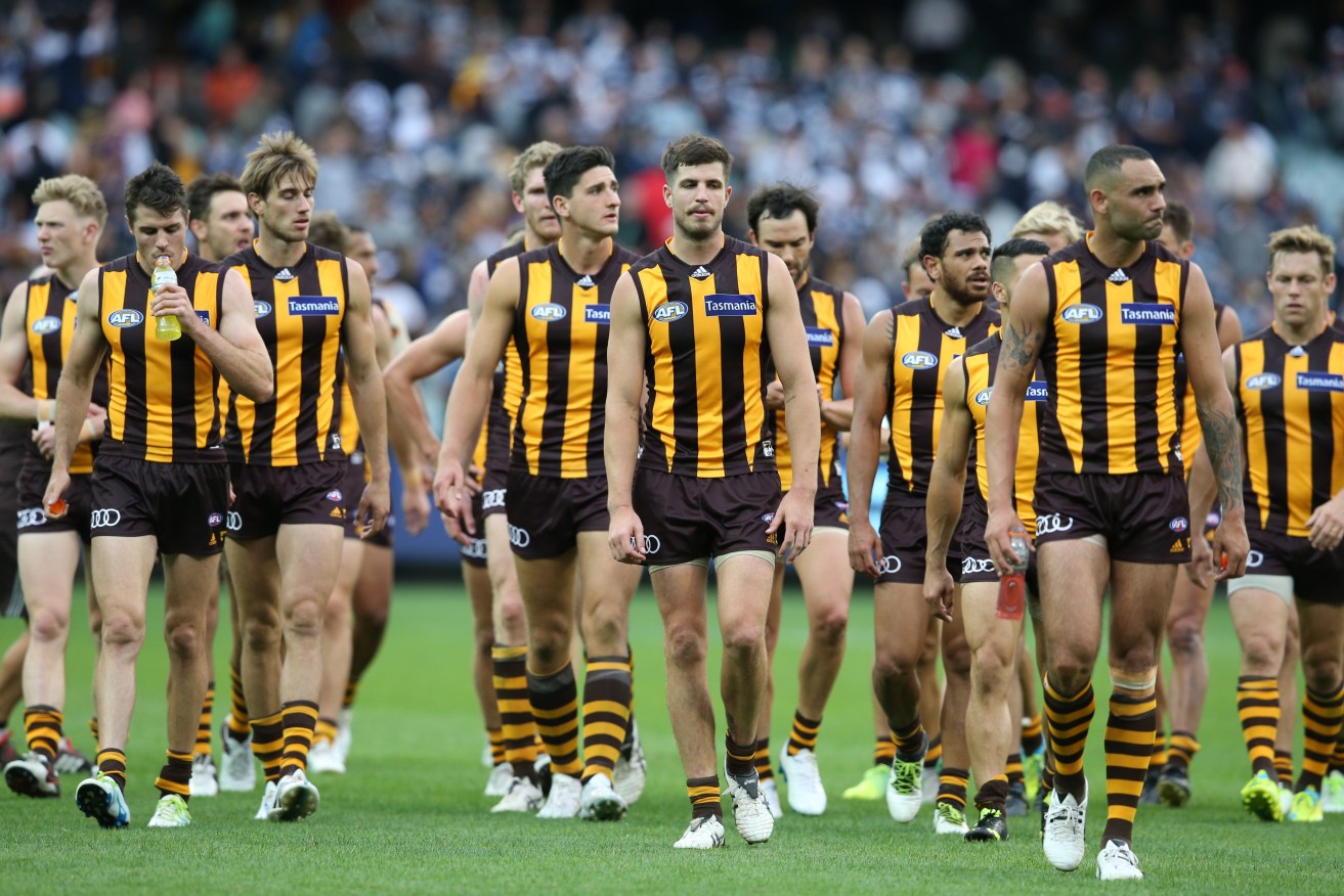 Dejected Hawthorn players leave the field after yesterday's loss to Geelong. Photo: David Crosling, AAP.