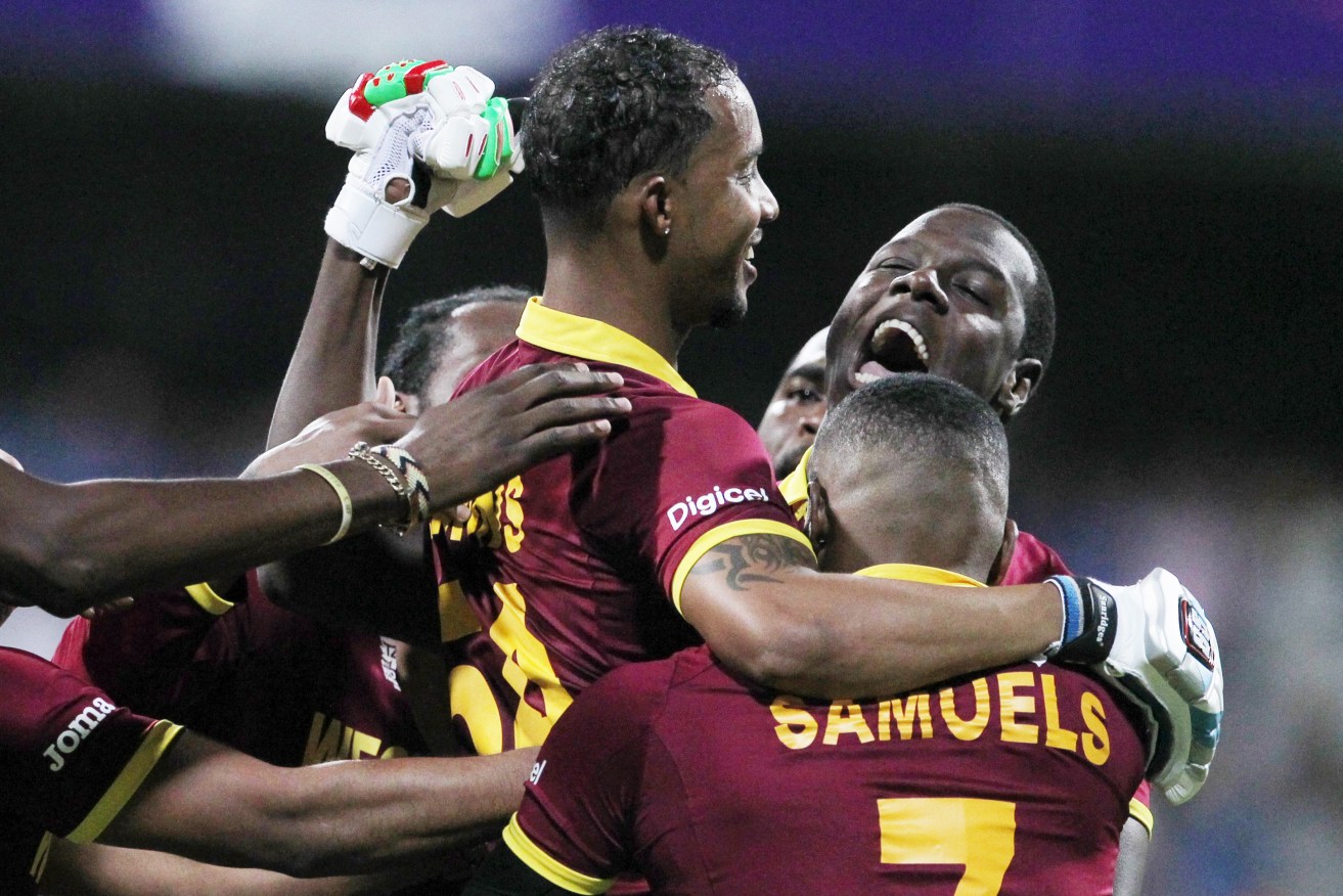 Lendl Simmons is held aloft by  teammates as they celebrate their seven wicket win over India. Photo: Rafiq Maqbool, AP.