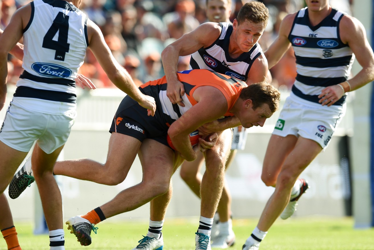 Cats captain Joel Selwood tackles former premiership teammate and now-Giant Steve Johnson. Photo: Lukas Coch, AAP.