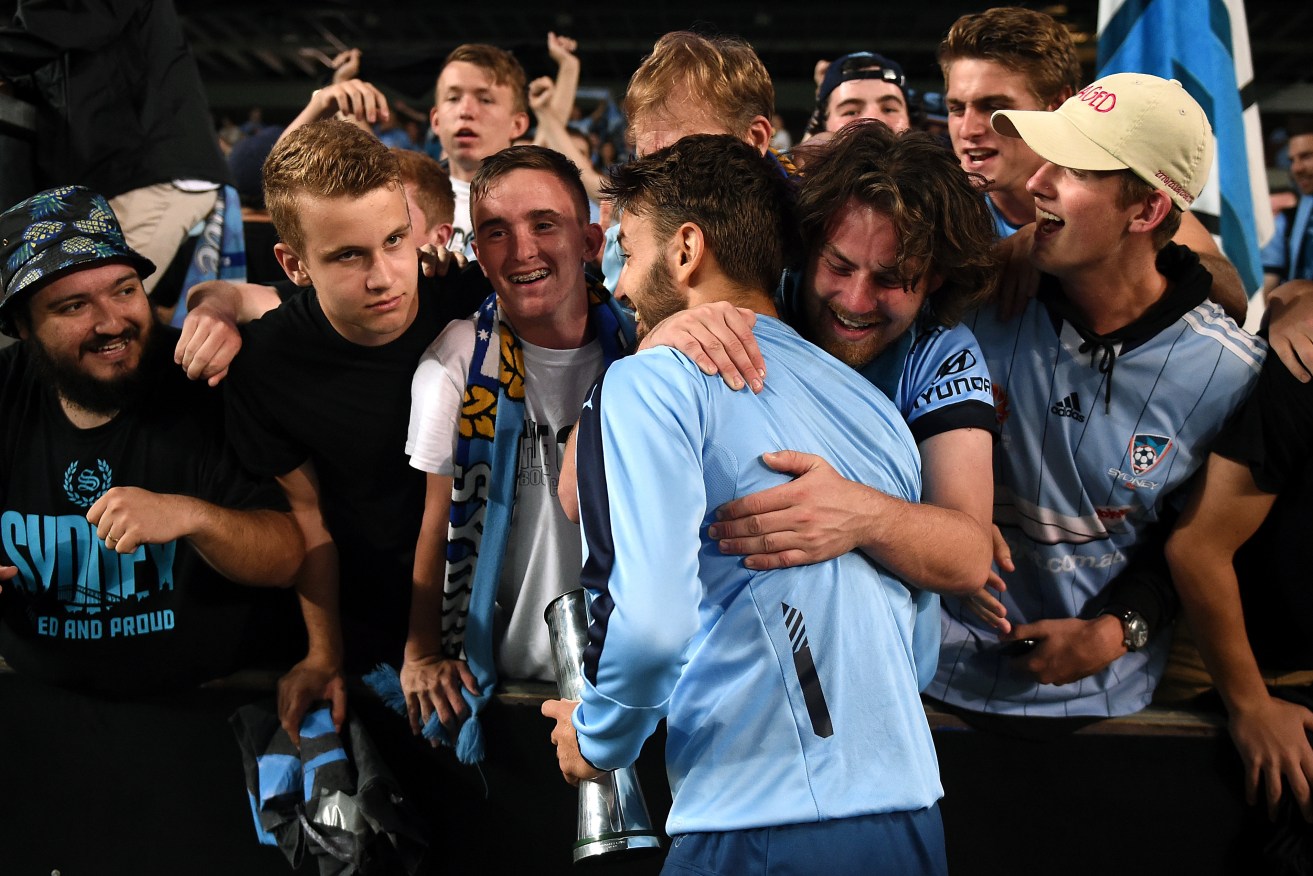 Sydney supporters embrace Milos Ninkovic following their win over the Pohang Steelers. Photo: Dan Himbrechts, AAP.