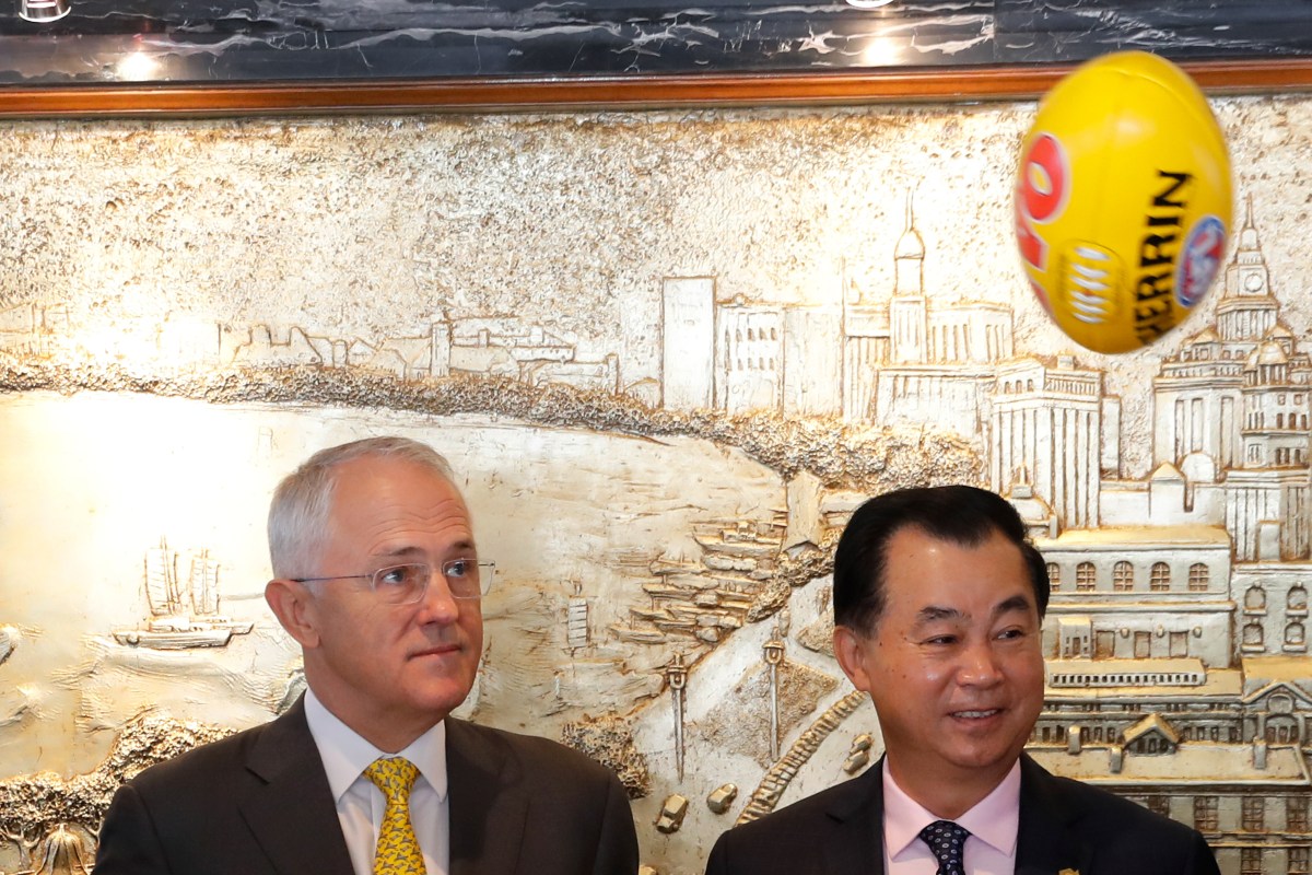 Prime Minister Malcolm Turnbull watches the Sherrin flying past Gui Guojie, general manager of Shanghai CRED Real Estate Stock, after a signing an MOU today. Photo: AP/Andy Wong