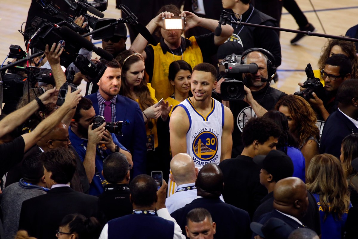 epaselect epa05257997 Golden State Warriors guard Steph Curry (C) speaks to the media after the NBA basketball game between the Golden State Warriors and the Memphis Grizzlies at the Oracle Arena in Oakland, California, USA, 13 April 2016. The Warriors won their 73rd game in a season, to break the NBA record of 72 wins in a season held by the 1995-96 Chicago Bulls.  EPA/MONICA M. DAVEY CORBIS OUT