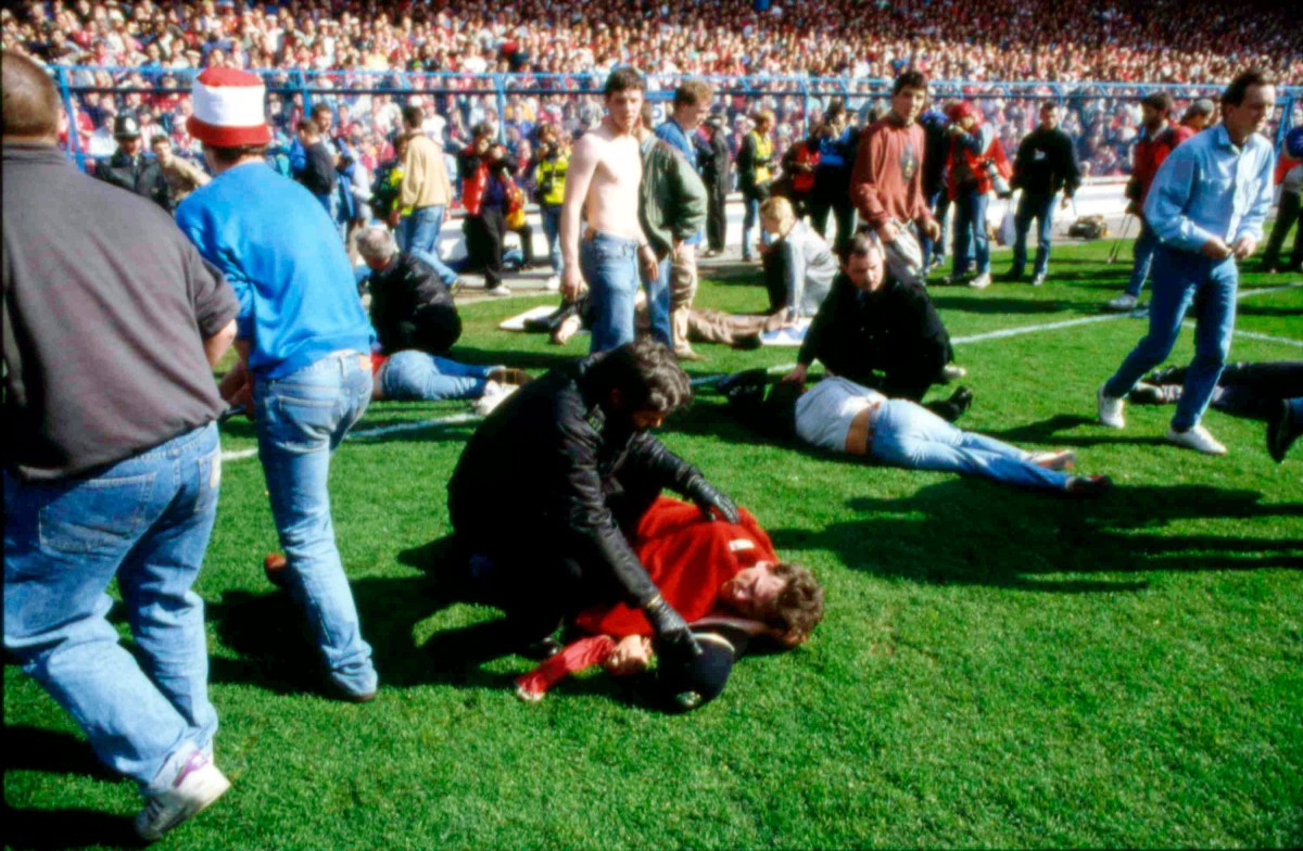 FILE - In this April 15, 1989 file photo police, stewards and supporters tend and care for wounded supporters on the field at Hillsborough Stadium, in Sheffield, England. The 96 Liverpool soccer fans who died in the Hillsborough Stadium disaster were unlawfully killed because of errors by the police, a jury concluded Tuesday April 26, 2016. (AP Photo, File)