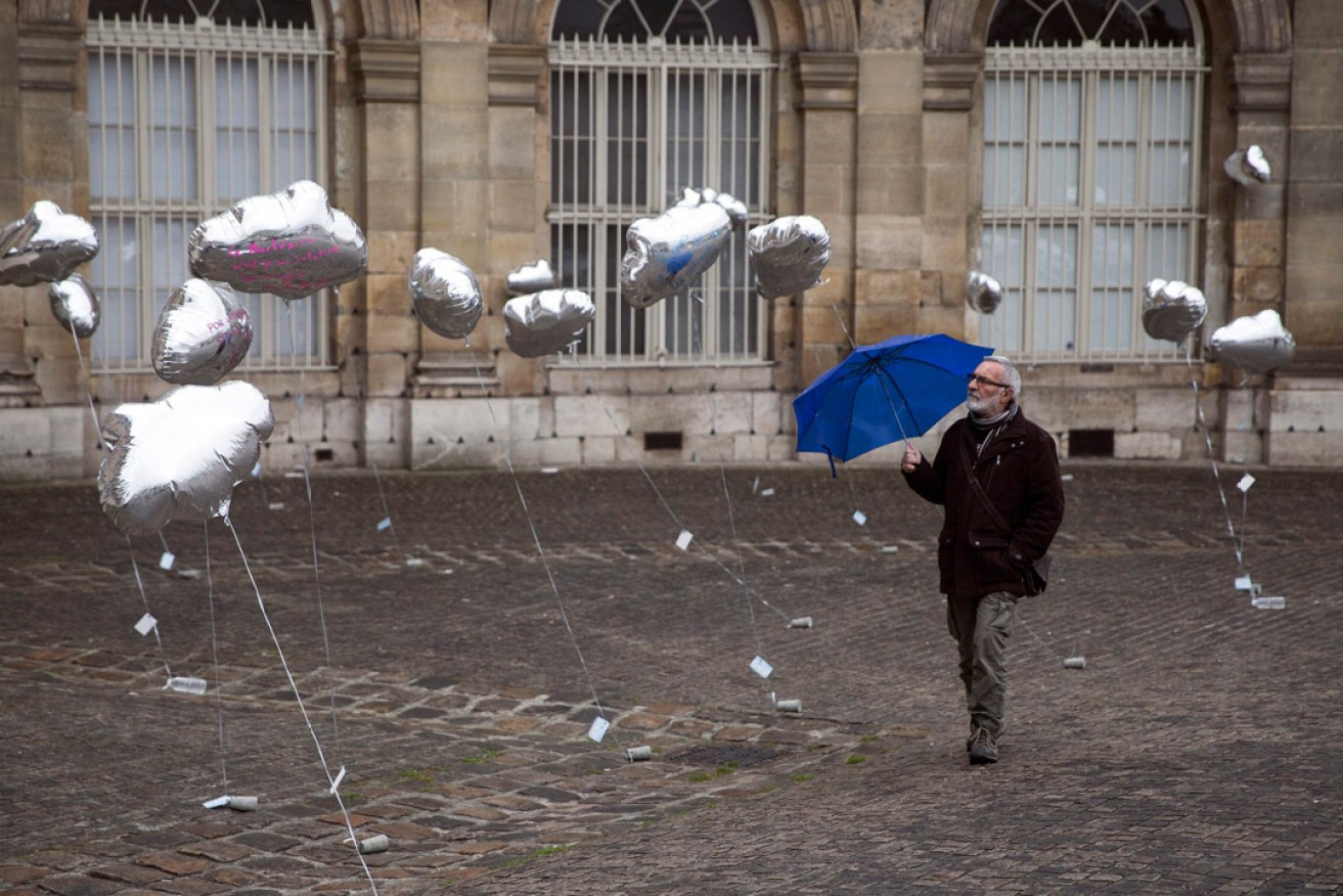 A man watches-cloud shaped balloons during a demonstration  in Paris against the use of nuclear power plants on the eve of the 30th anniversary of the Chernobyl disaster. Photo: EPA