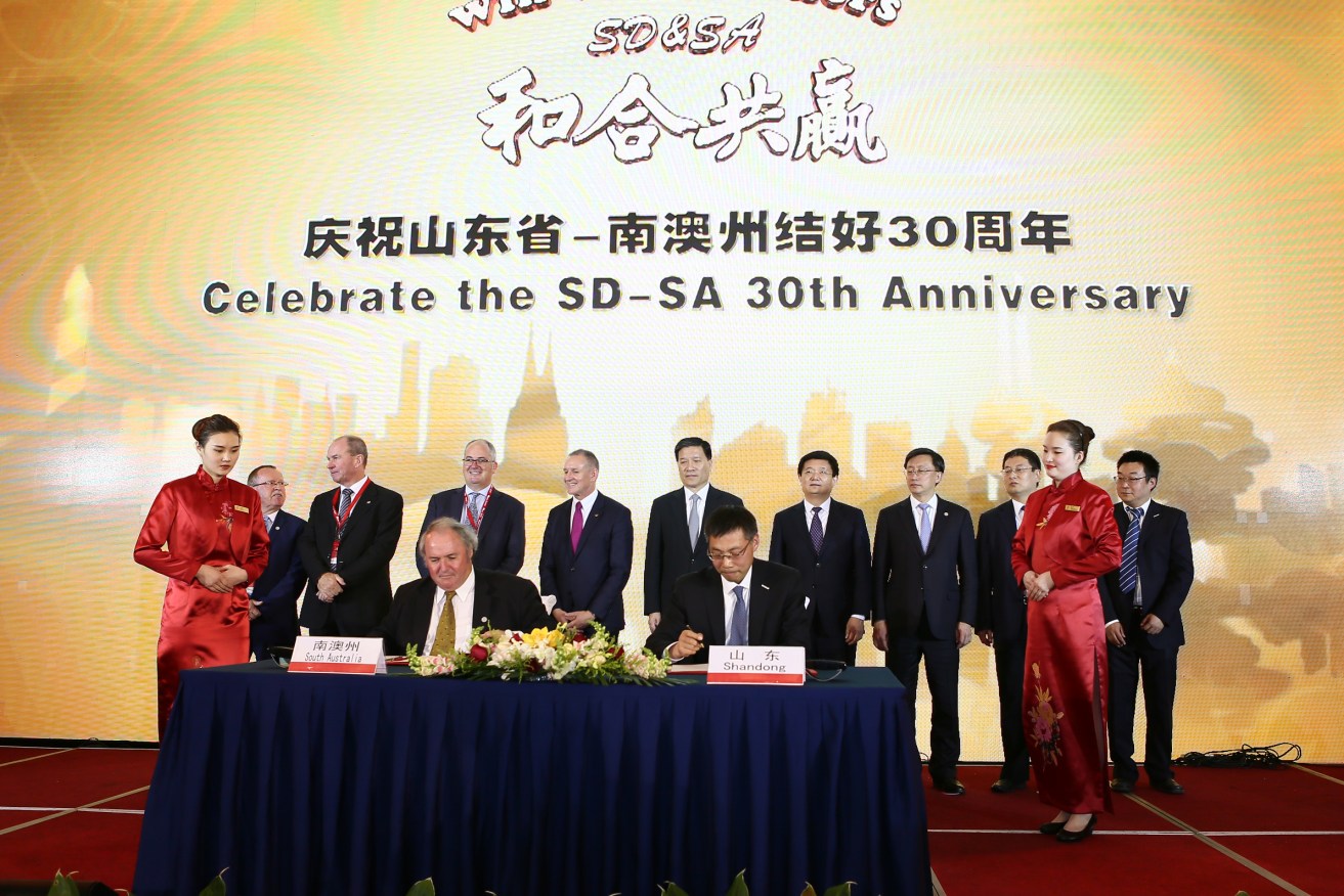Jay Weatherill and other delegates sign an agreement with ICT company Inspur on their China trade mission. Also on the trip are delegates from the three SA universities - and a businessman who says they should merge their operations. Photo: Supplied.