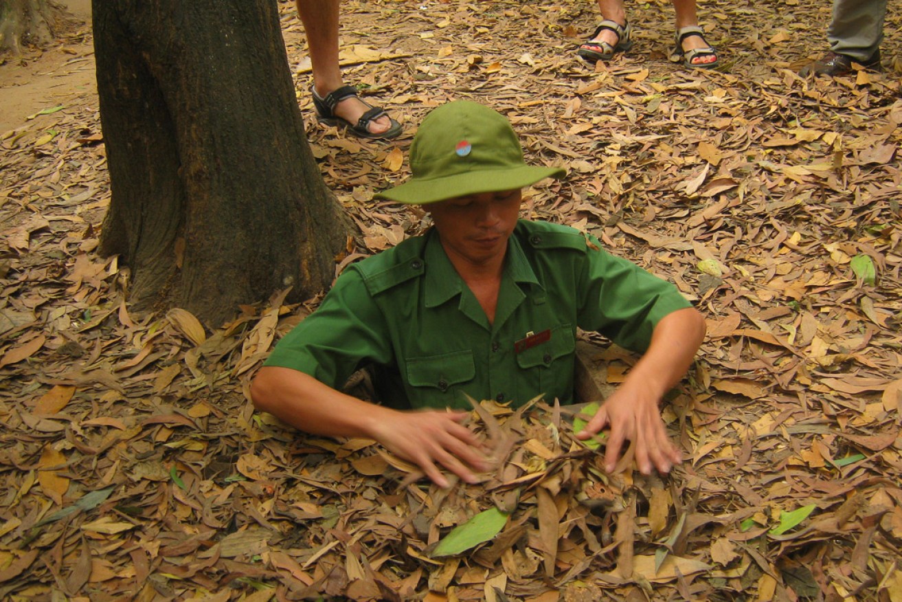 A tour guide at the entrance to one of the Cu Chi tunnels. Photo:  Mario Ray Borg / flickr