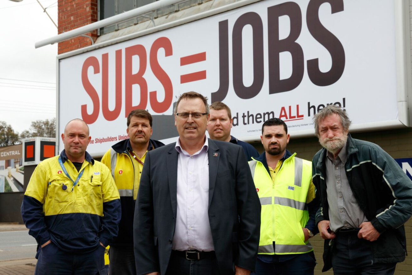 Glen Dallimore, second from left, joins fellow AMWU stalwarts David Coulthard, Glenn Thompson, Matthew Premio, Daniel Sweet and Tony Evans at the launch of a billboard campaigning for a local submarine build. Photo: AMWU.org.au