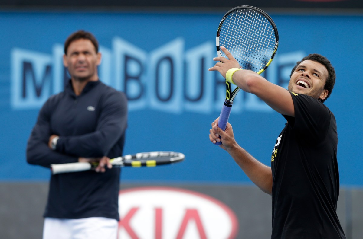 France's Jo-Wilfried Tsonga looks to play a forehand smash as his coach Roger Rasheed looks on during a practice session on Margaret Court Arena ahead of the Australian Open tennis championship in Melbourne, Australia, Sunday, Jan. 13, 2013. (AP Photo/Andy Wong)