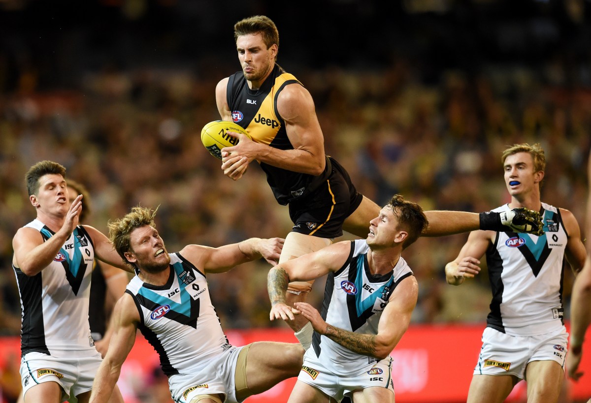 Shaun Hampson of the Tigers leaps over Power players during the round 6 AFL match between the Richmond Tigers and the Port Adelaide Power at the MCG in Melbourne, Saturday, April 30, 2016. (AAP Image/Tracey Nearmy) NO ARCHIVING, EDITORIAL USE ONLY