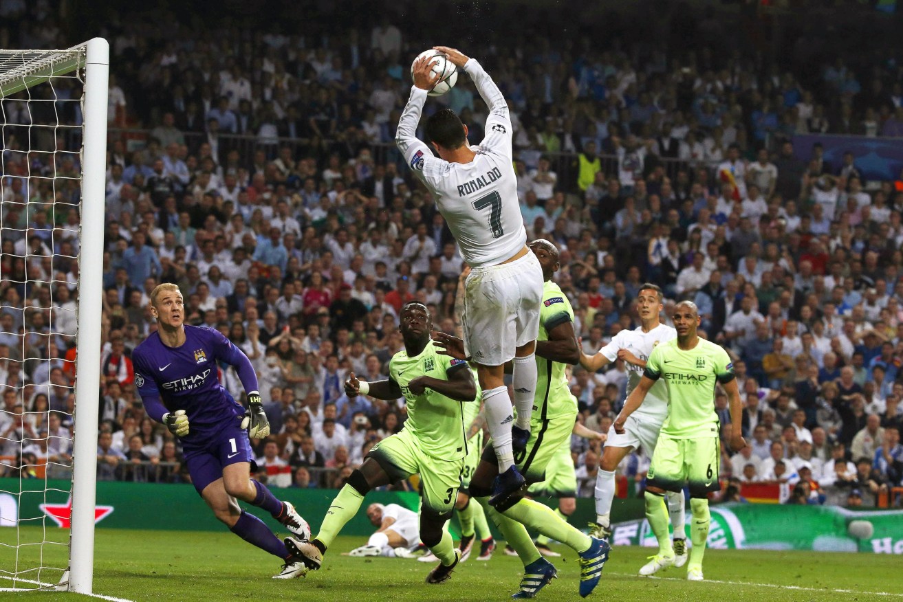 Portuguese striker Cristiano Ronaldo catches the ball during the Champions League semi final. Photo: KIKO HUESCA, EPA.