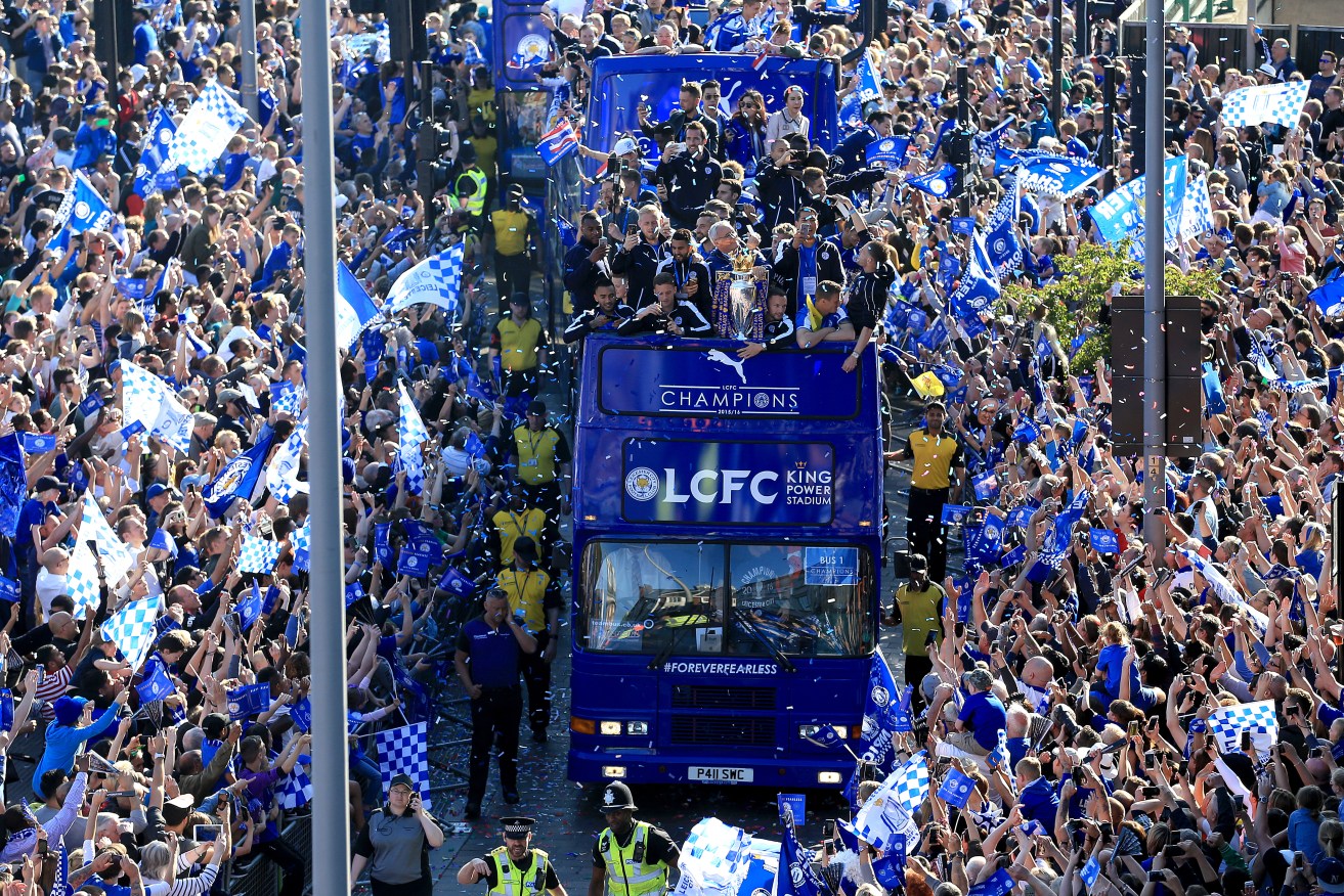 Leicester City players and staff celebrate with the trophy during the open top bus parade through Leicester City Centre. Photo: Tim Goode, PA Wire.